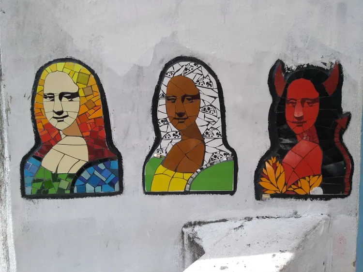Three Mona Lisa mosaics on a wall